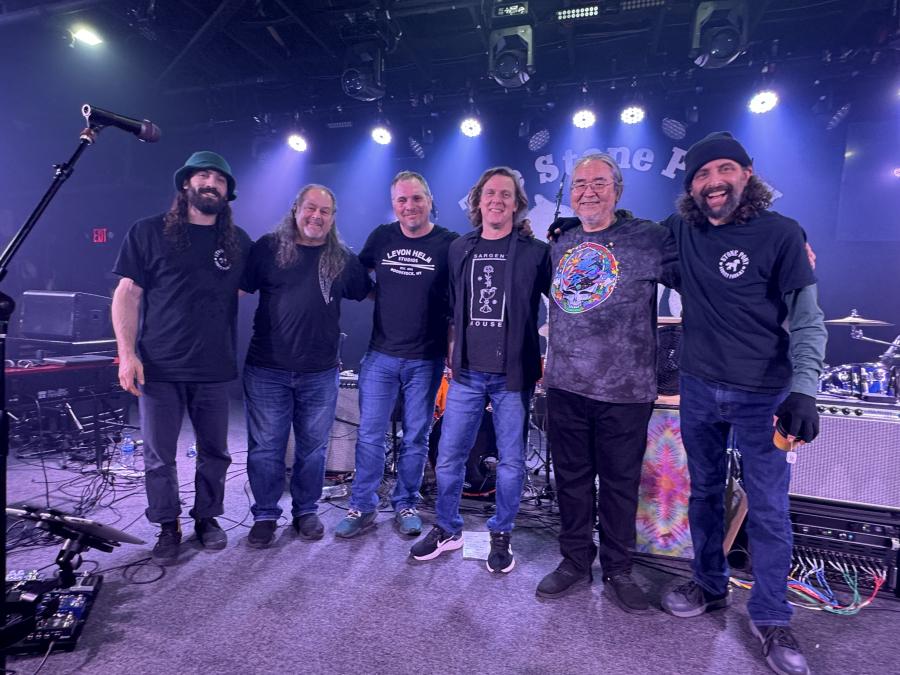 Members of Splintered Sunlight posing on a lit stage.